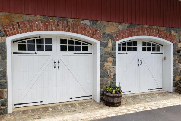 A pair of Artisan Custom Wood Doors in white with windows and hardware.