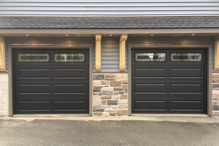 Two single bay raised panel doors in black with Hawthorne Glass.